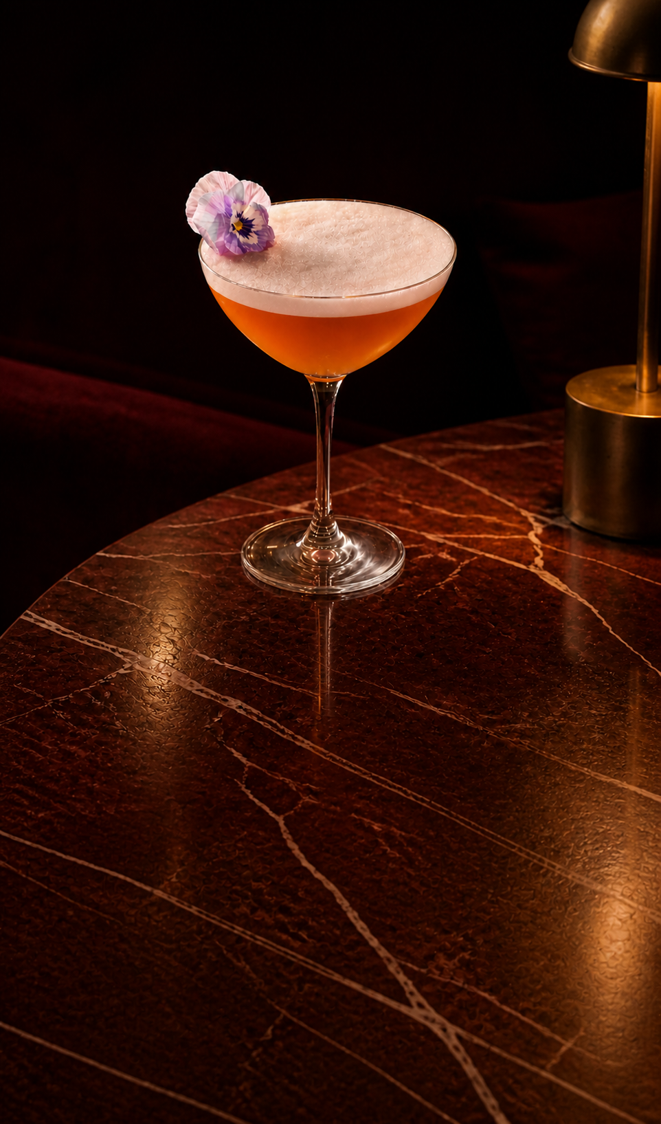 Blush sour in a coupe with a pansy garnish